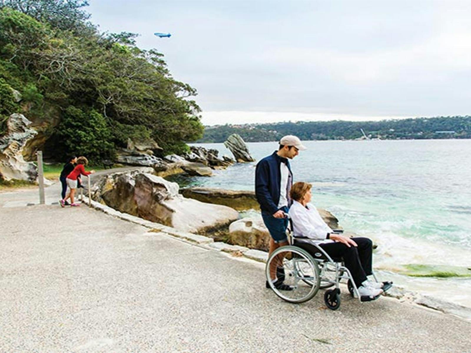 Wheelchair user admiring views of Shark Beach from the wheelchair accessible path in Nielsen Park.