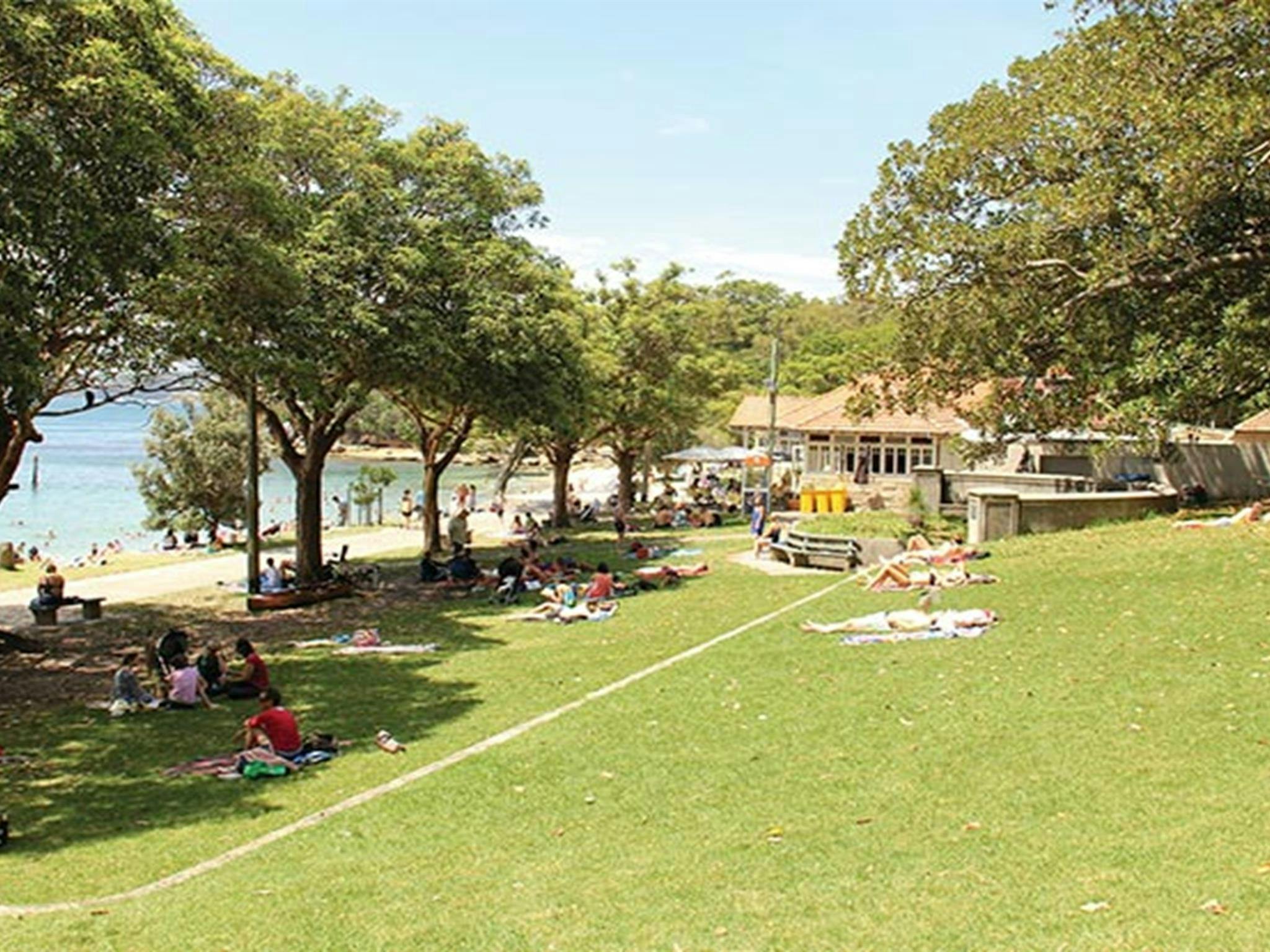 People relaxing on the grassy area in Nielsen Park. Photo: John Yurasek/DPIE