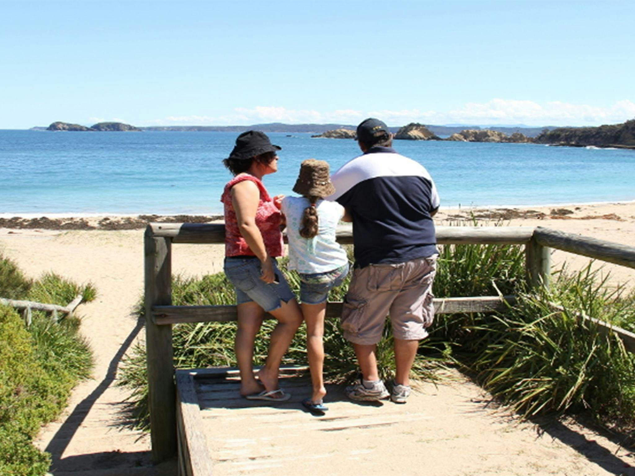Family at a lookout over North Head Beach in Murramarang National Park. Photo: John Yurasek/DPIE