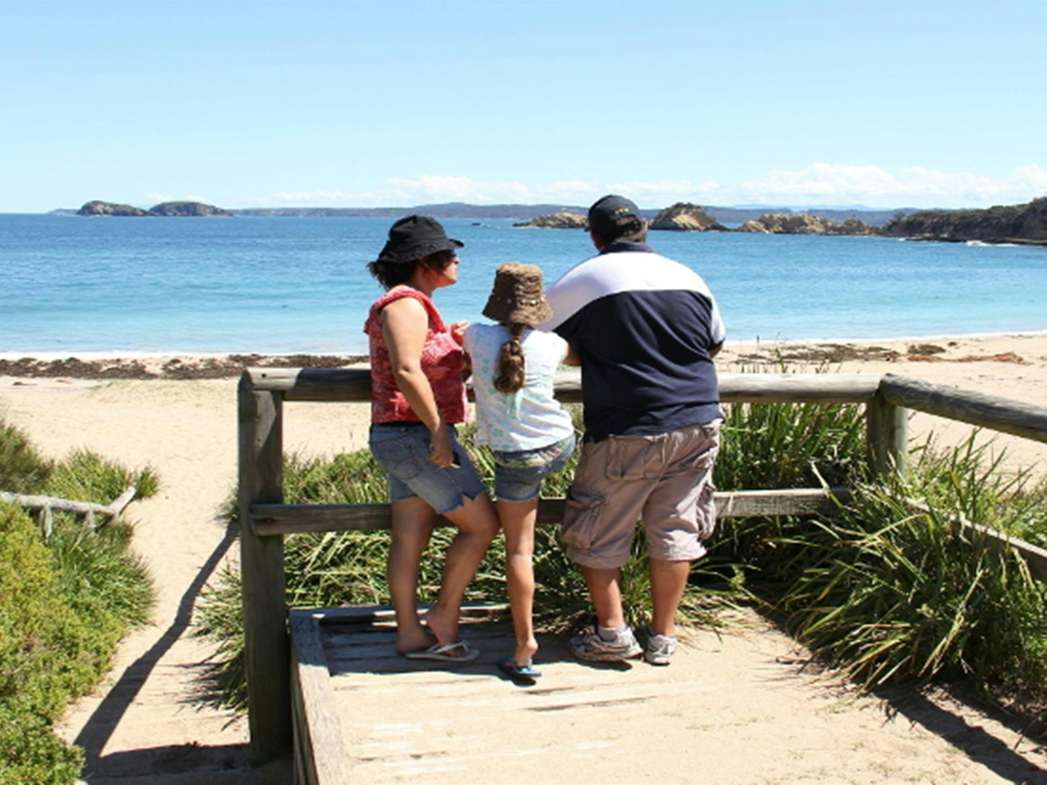 Family at a lookout over North Head Beach in Murramarang National Park. Photo: John Yurasek/DPIE