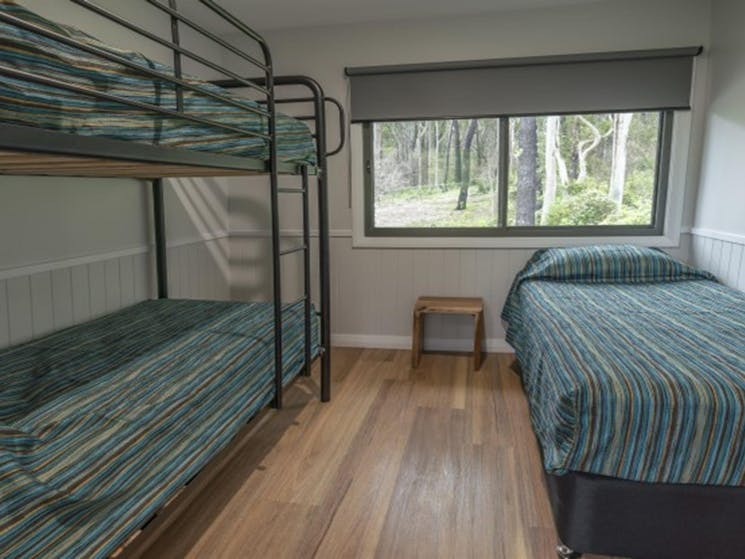 A bedroom with single and bunk bed at Pebbly Beach shacks in Murramarang National Park. Photo: John