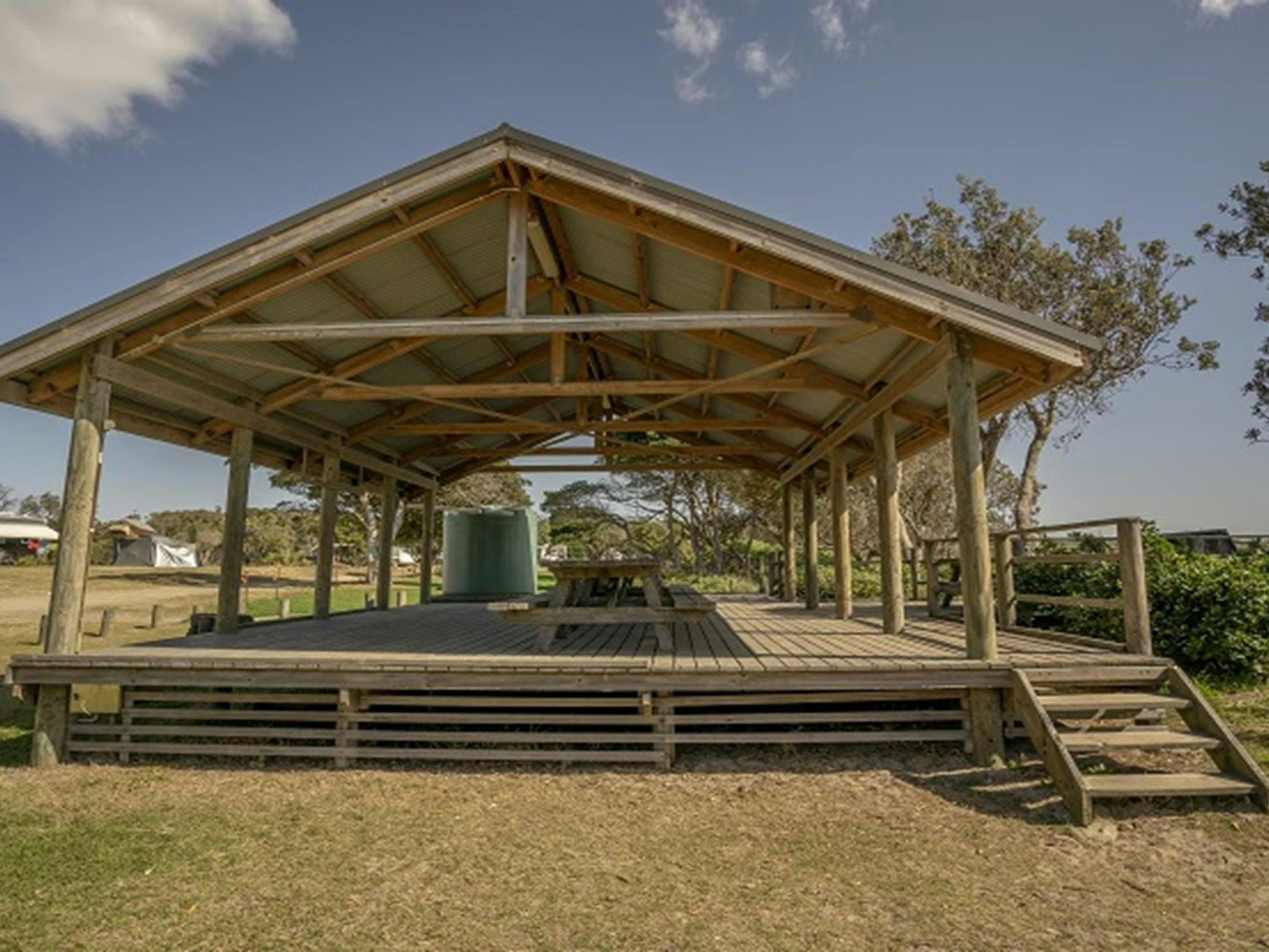 Picknicktische mit großem Unterstand auf dem Campingplatz Point Plomer im Limeburners Creek Nationalpark. Foto: