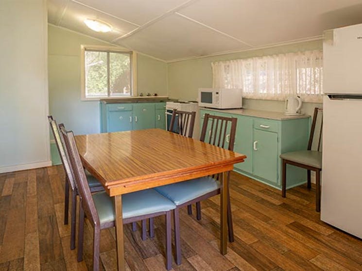 Kitchen of Post Office Cottage with dining table, fridge, oven and microwave. Photo: OEH/John