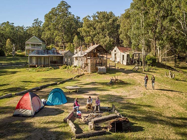 Campers sitting around the fire pit near their tents at Private Town campground in Yerranderie