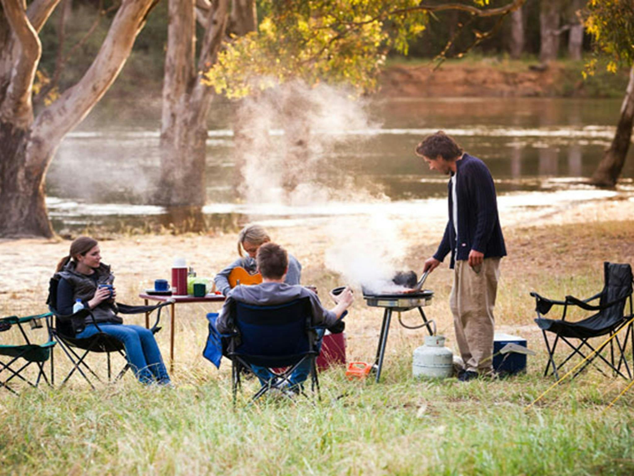 Friends cooking dinner at Quicks Beach campground. Photo: David Finnegan/NSW Government