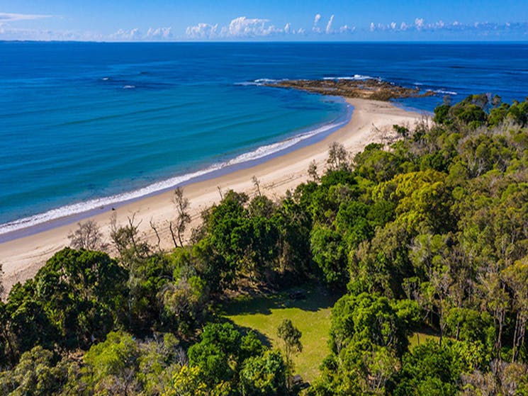Aerial view of Shark Bay picnic area set in bushland, next to beach with rocky headland in the