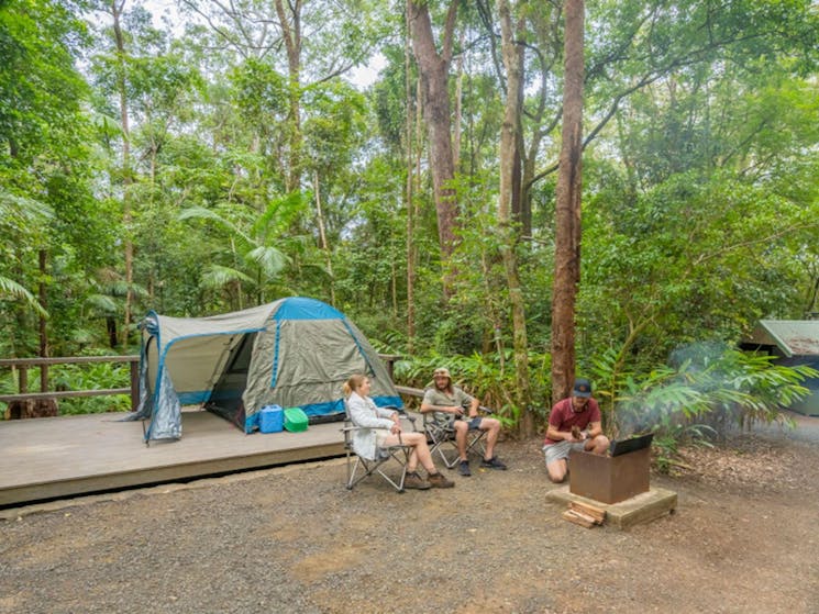 3 campers relaxing at their tent platform at Sheepstation Creek campground. Photo credit: John