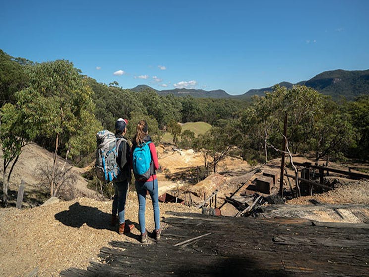 A couple looking across the remnants of historic Silver Peak Mine to Yerranderie Regional Park.