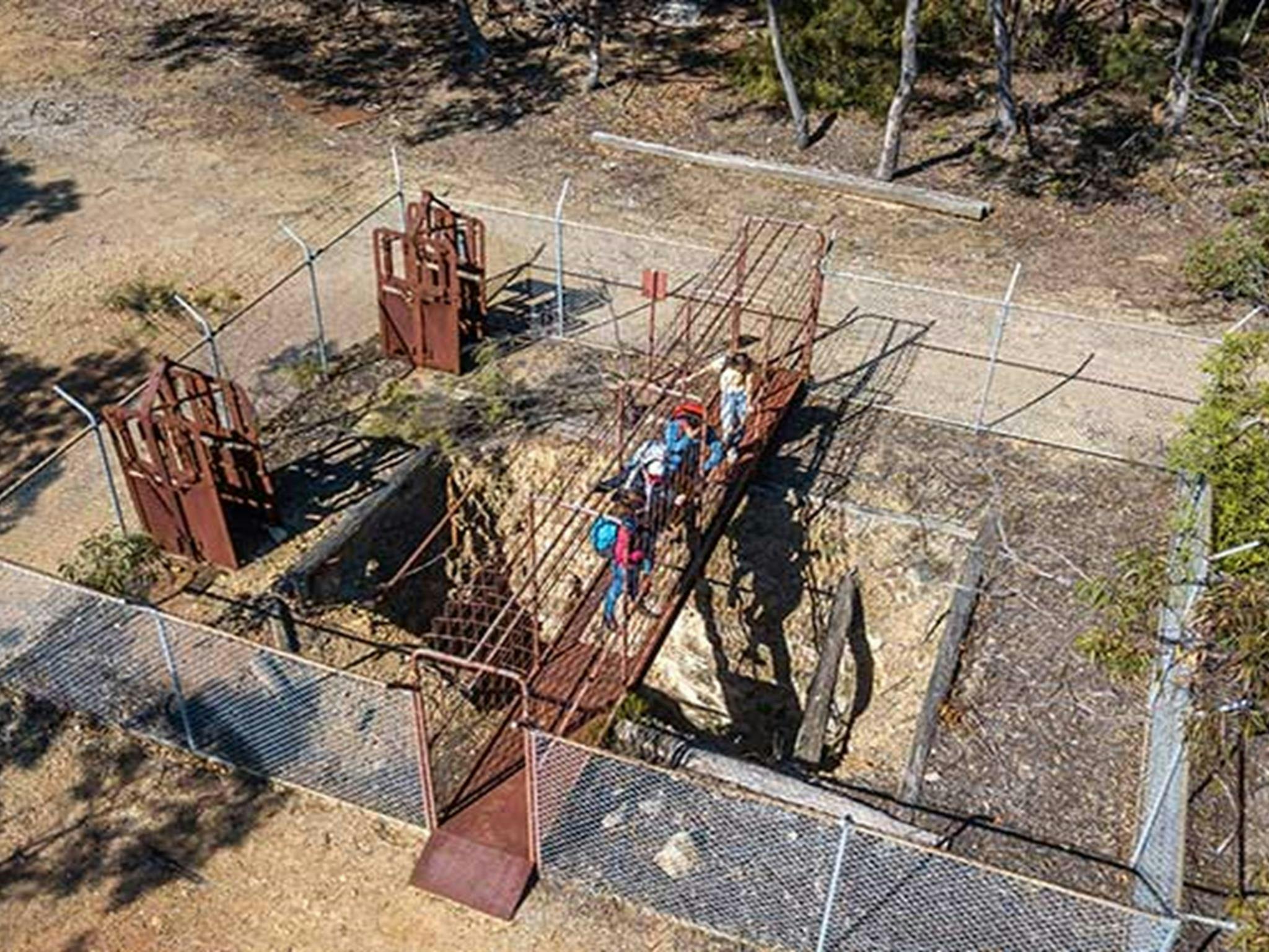 Luftaufnahme von Menschen, die auf einer Metallbrücke über der Silver Peak Mine in der Nähe der Privatstadt Yerranderie stehen.