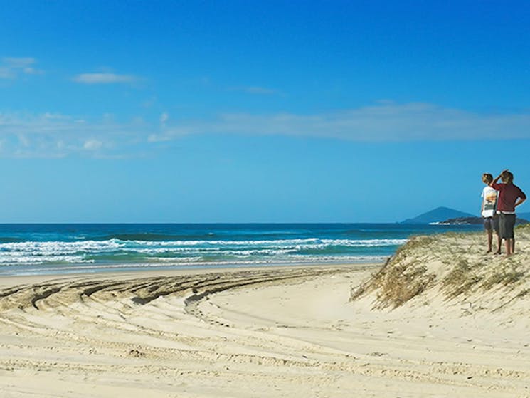 2 people on the beach at Smoky Cape campground in Hat Head National Park. Photo: Debby McGerty/DPIE