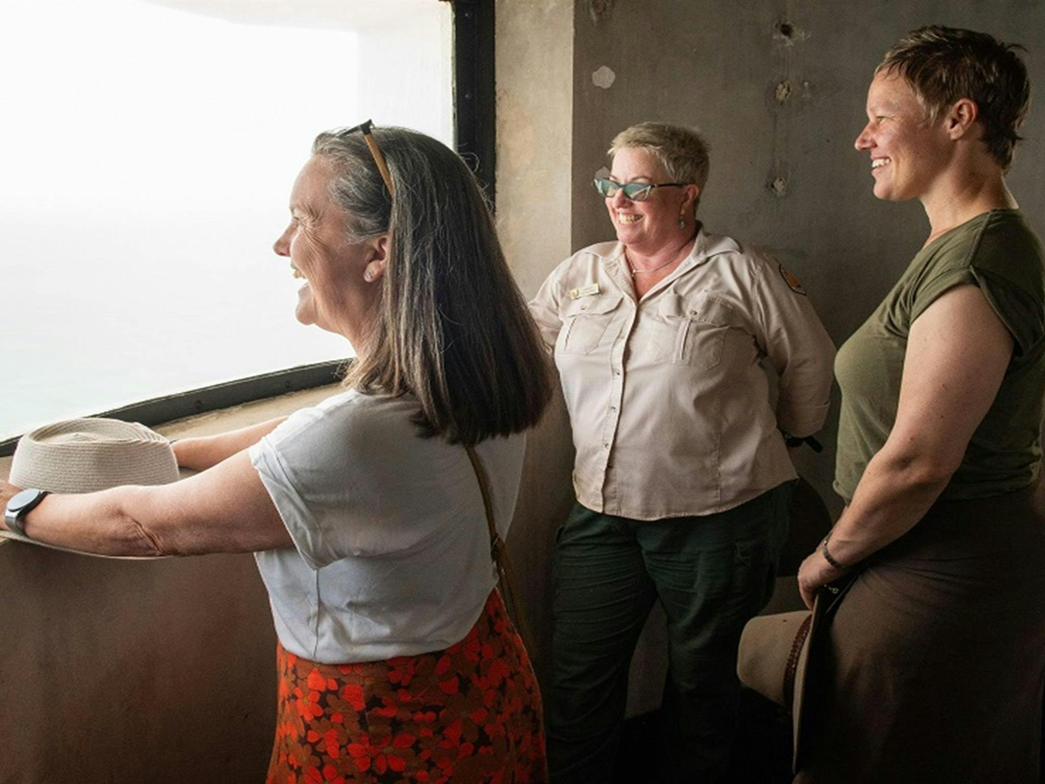 游客们在攀登灯塔的过程中，会驻足欣赏从弧形灯塔窗户望出去的景色。