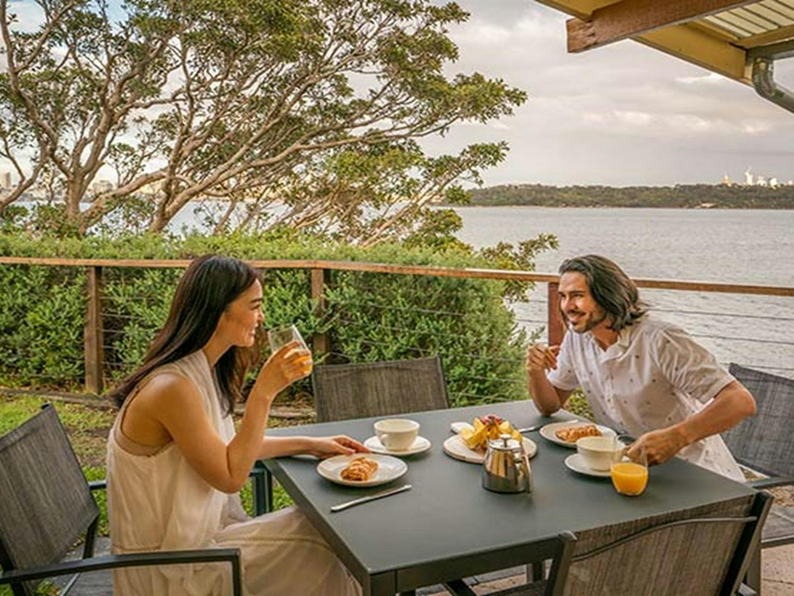 Guests eating breakfast in the outdoor seating area at Steele Point Cottage. Photo: John Spencer/OEH