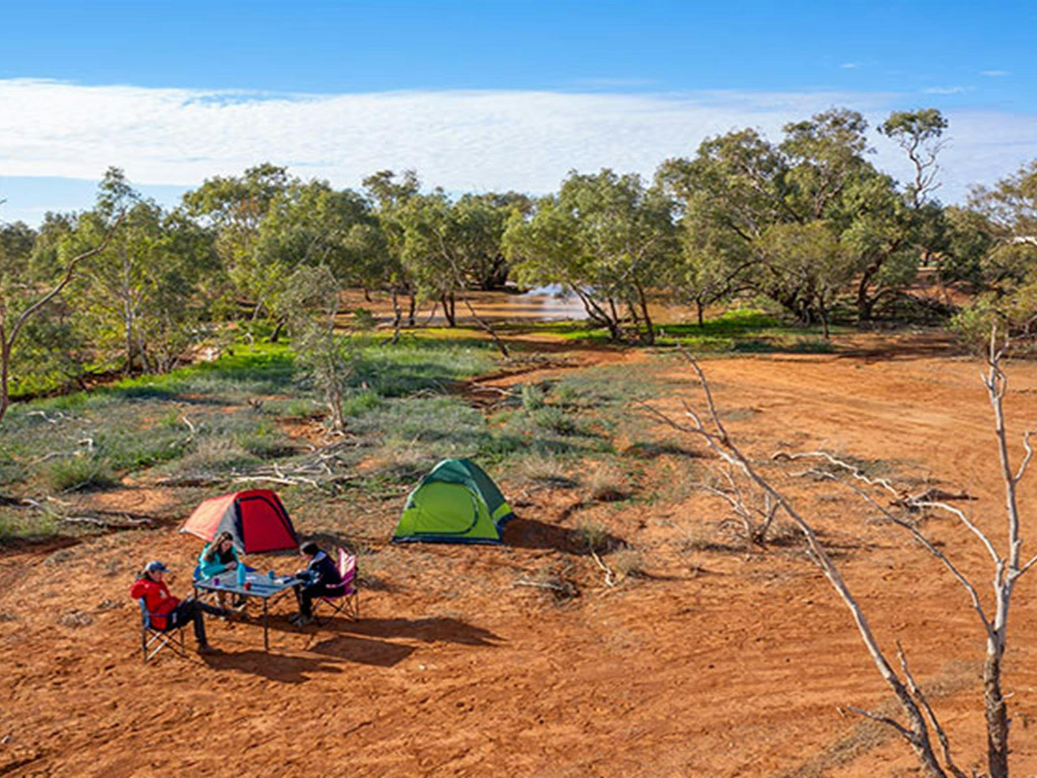 Camper spielen Karten in der Nähe ihrer Zelte auf dem Campingplatz Mount Wood. Foto: John Spencer/DPIE