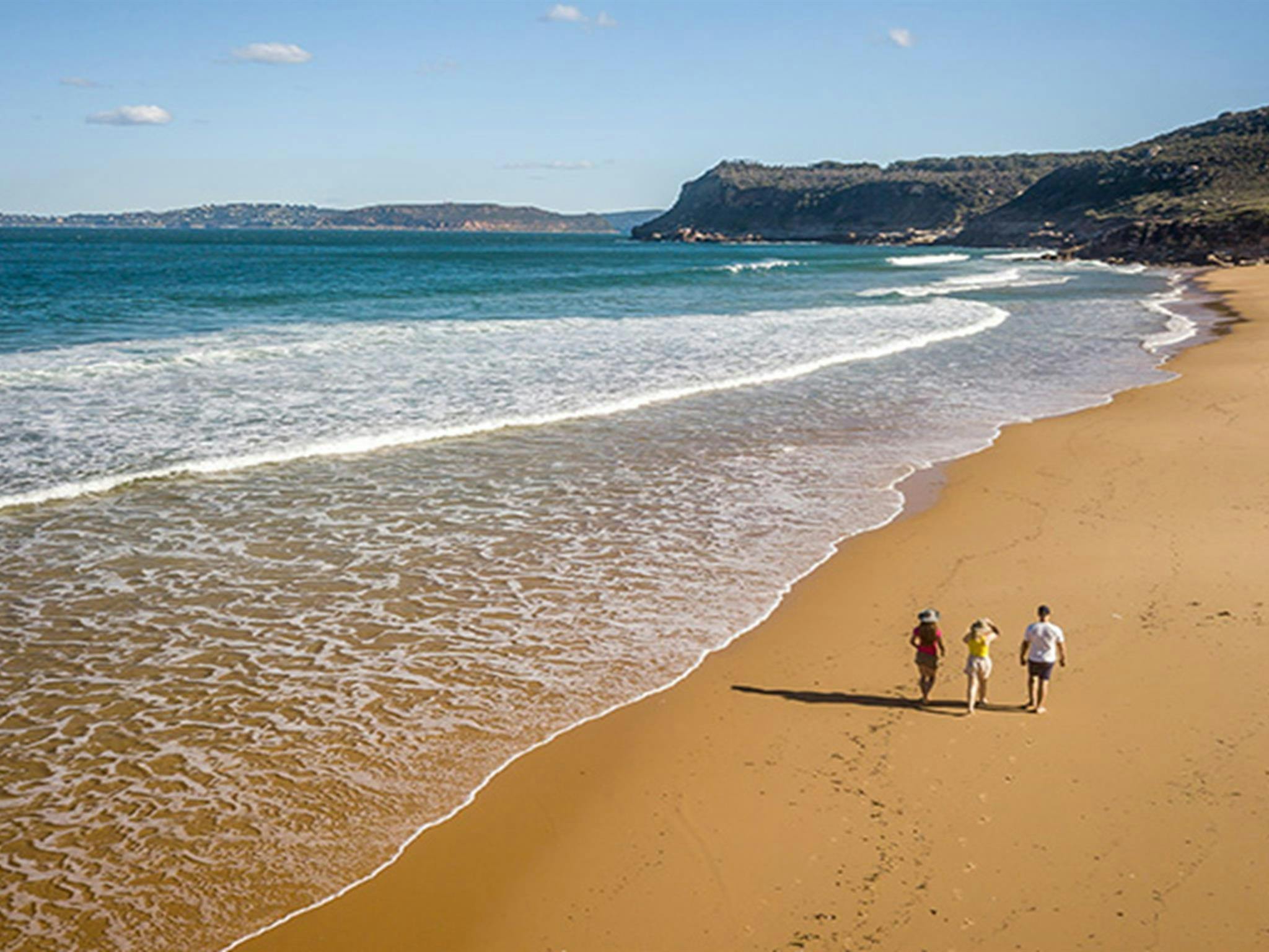 Luftaufnahme von drei Personen, die am Tallow Beach im Bouddi-Nationalpark entlangspazieren. Foto: John Spencer/DPIE.