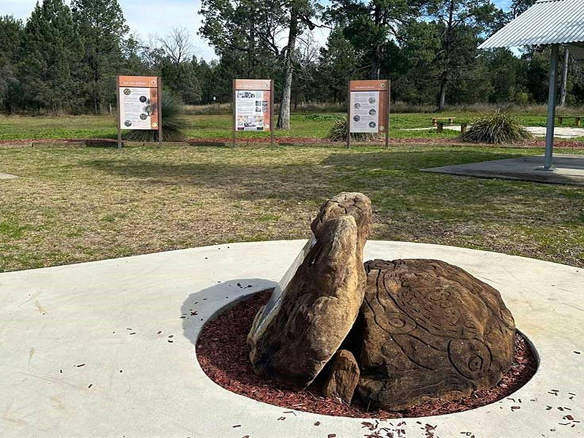 Ein Felsen mit Gravuren der Aborigines, Informationstafeln und Unterständen für Terry Hie Hie Aboriginal