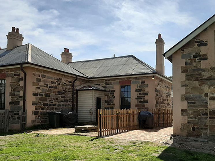 Exterior of the Post Office Residence and The Stables, with a small fence separating the two