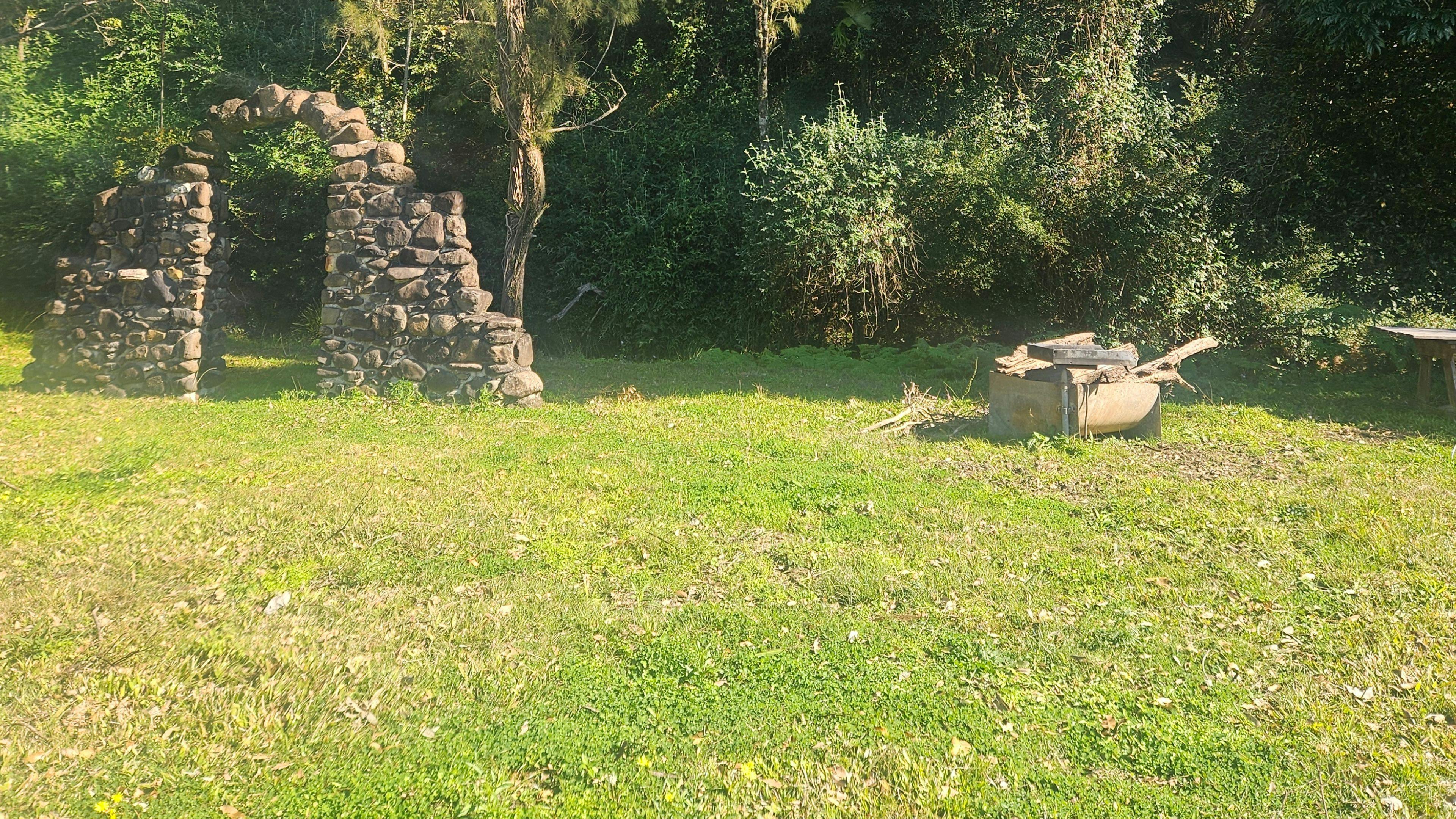 The Camp Site with fire pit and bbq plate and table