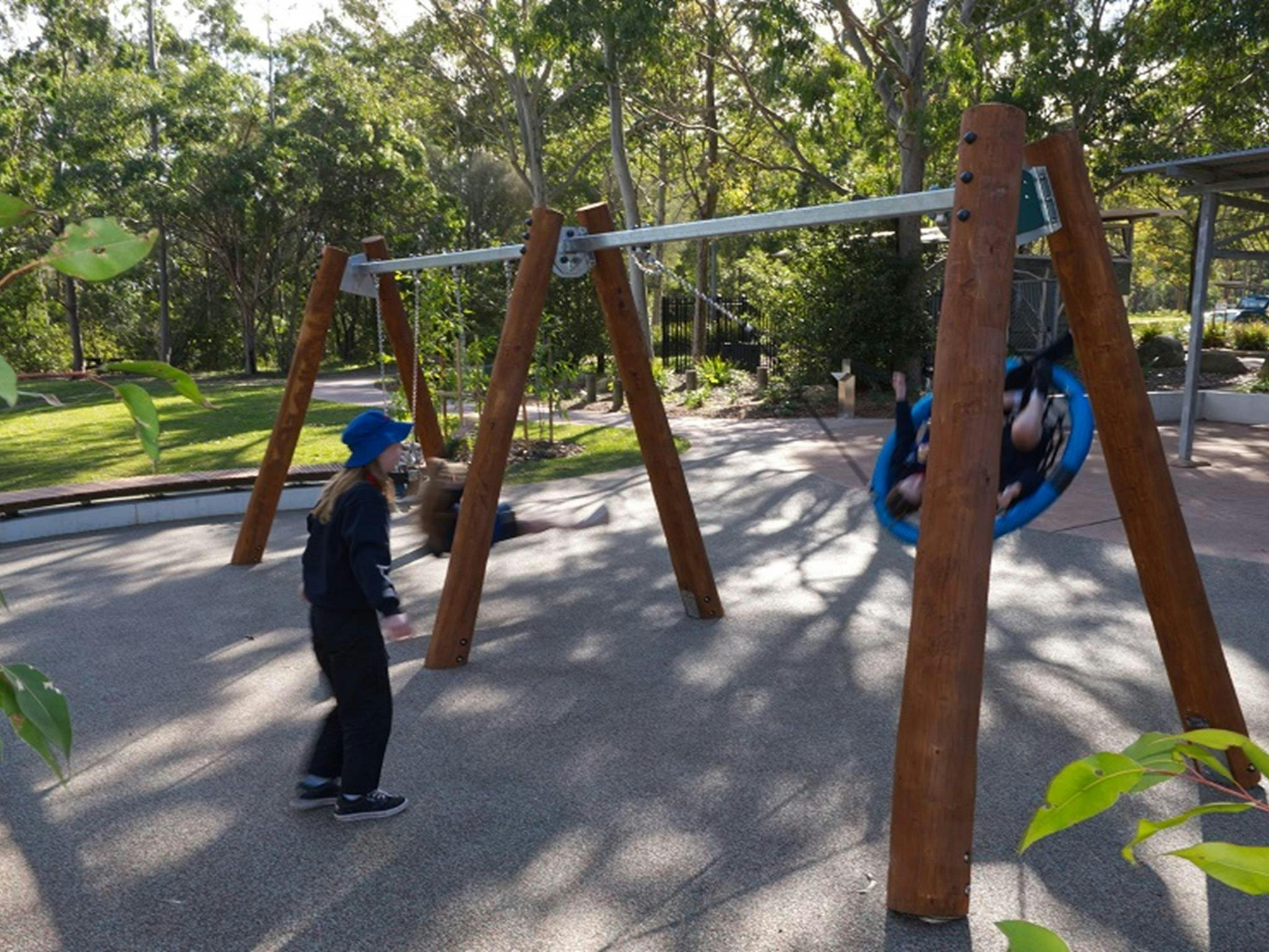 Children play on the swings at Village Green picnic area and playground, Blue Gum Hills Regional