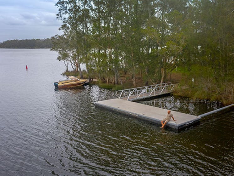 A man sitting on the wharf at Violet Hill campground in Myall Lakes National Park. Photo; John