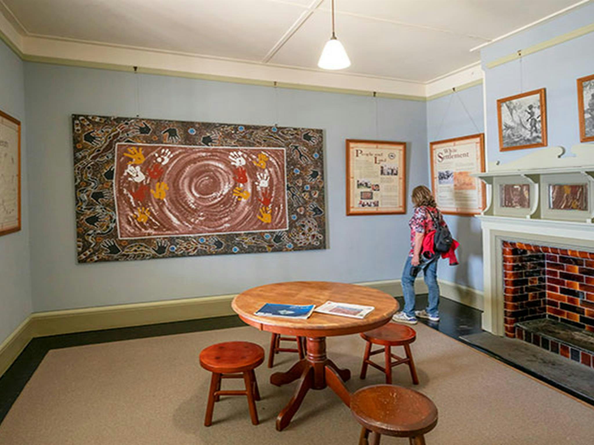 A woman viewing artwork at Walgun Cape Byron Information Centre in Walgun Cape Byron State
