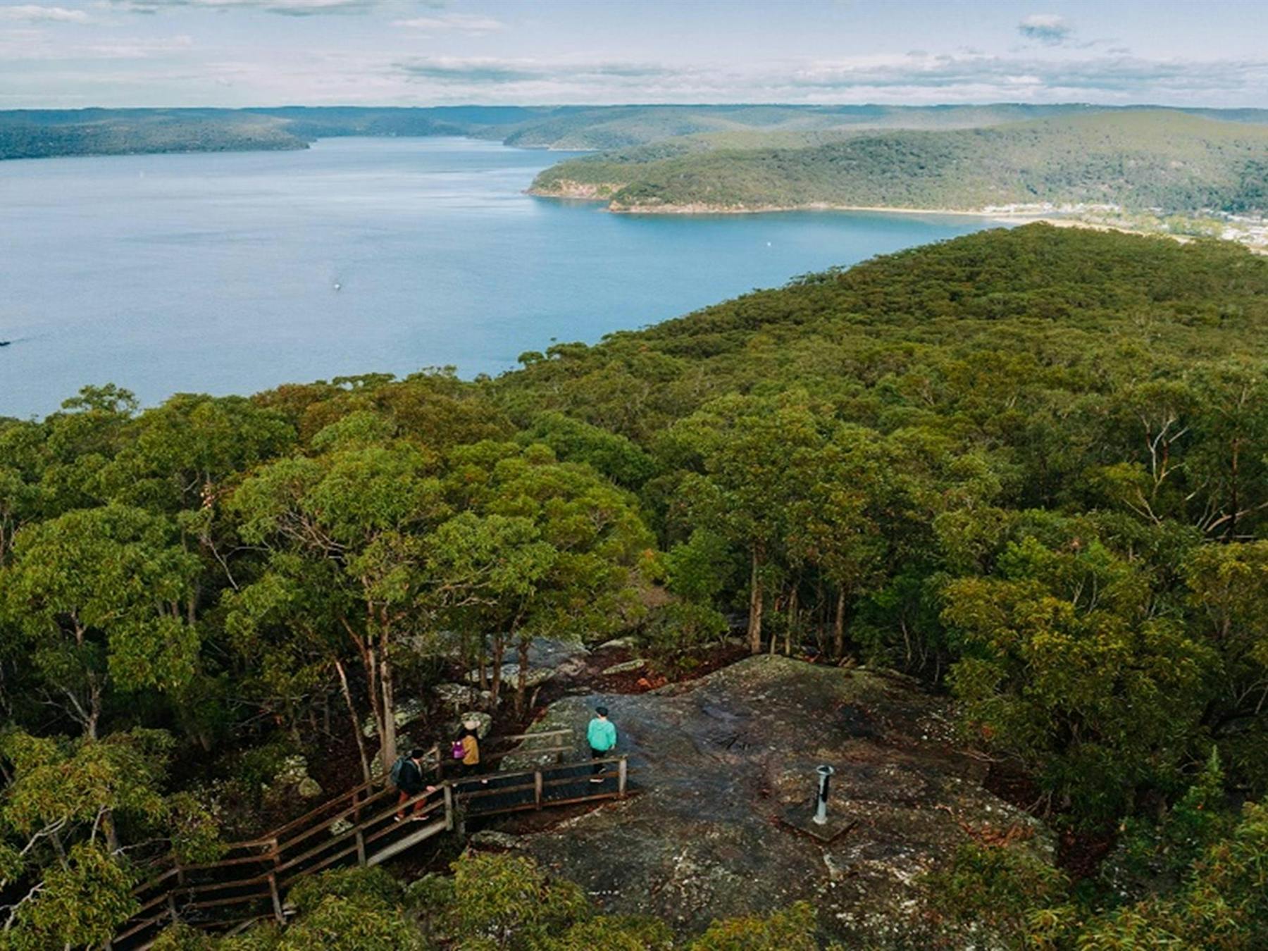 Aerial view of hikers along Warrah Trig walking track framed by the picturesque Hawkesbury River.