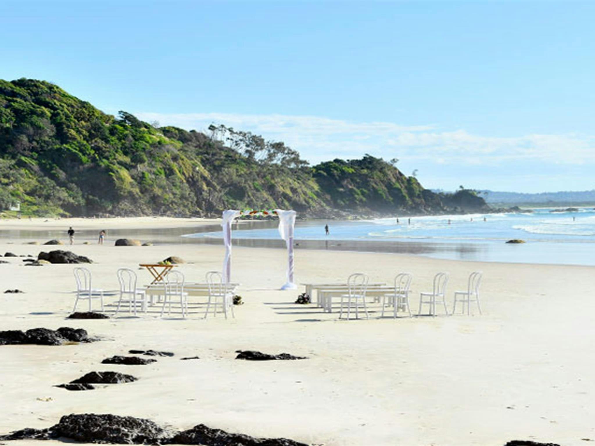 在纽约州拜伦角瓦特戈斯海滩，为一场婚礼布置了婚礼拱门、长椅和椅子。