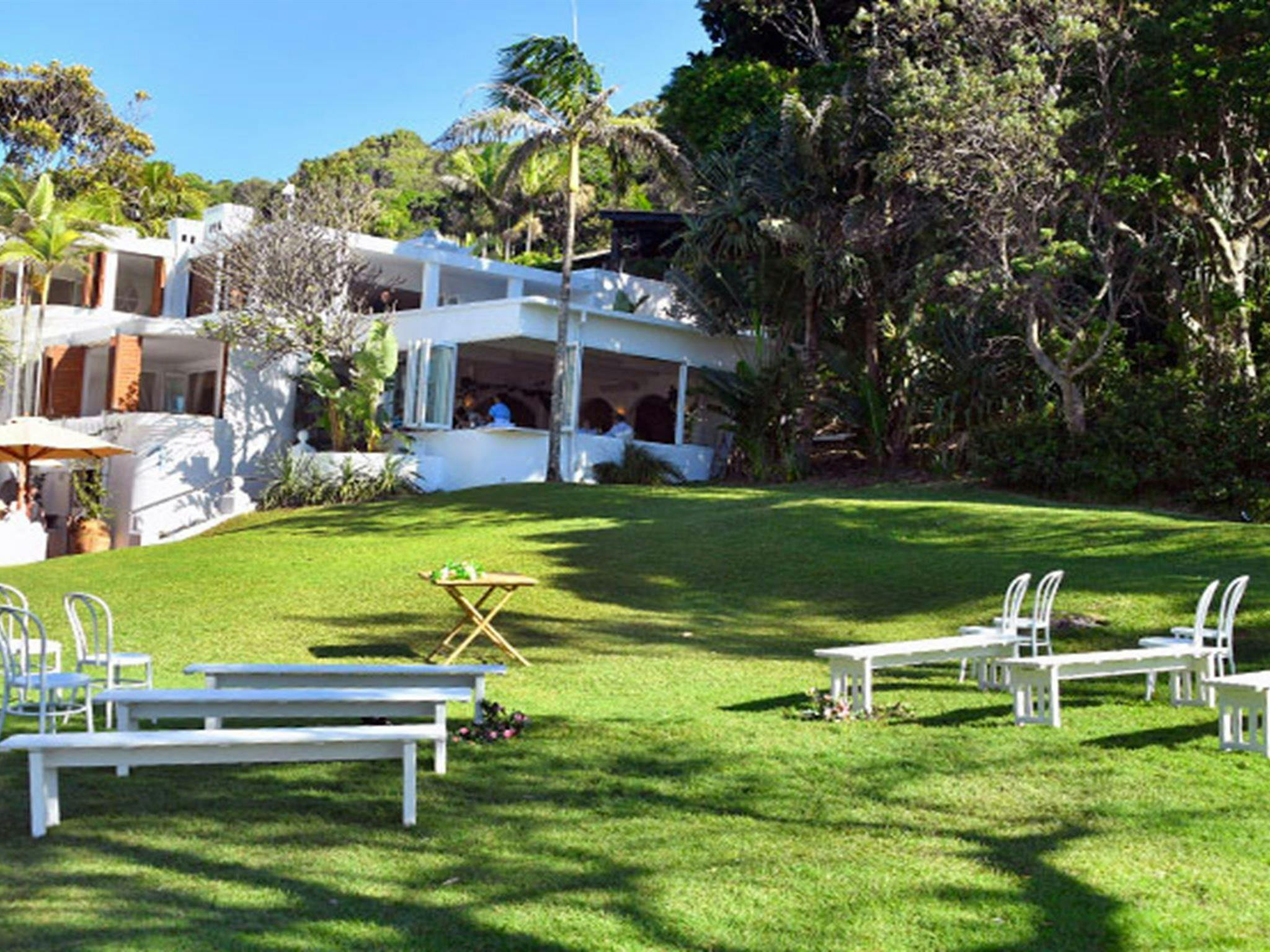 Chairs and benches set up on Wategos lawn for a wedding ceremony in Cape Byron State Conservation