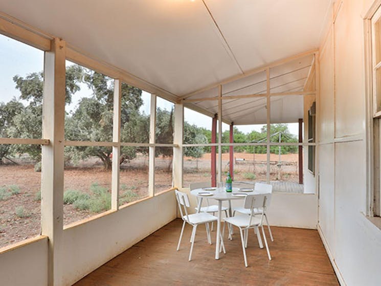 Enclosed verandah with table and chairs at Willandra Cottage, Willandra National Park. Photo: Vision