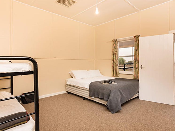 Queen bed and bunk bed in a bedroom at Willandra Cottage, Willandra National Park. Photo: Vision