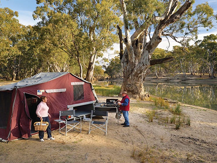 Campers using a barbecue outside their tent by the river bank, Murray Valley Regional Park. Photo: