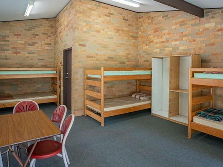 Three bunks beds and a communal table in one of the rooms in Wombeyan Caves dormitories. Photo:
