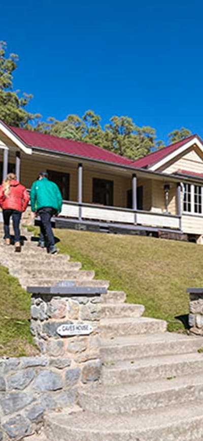 A couple at entry steps to Yarrangobilly Caves House East and West wings, Kosciuszko National Park.
