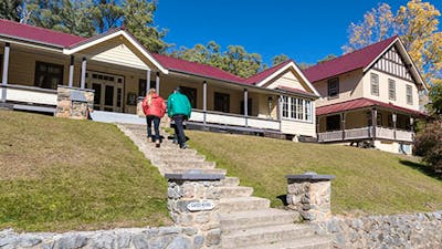 A couple at entry steps to Yarrangobilly Caves House East and West wings, Kosciuszko National Park.