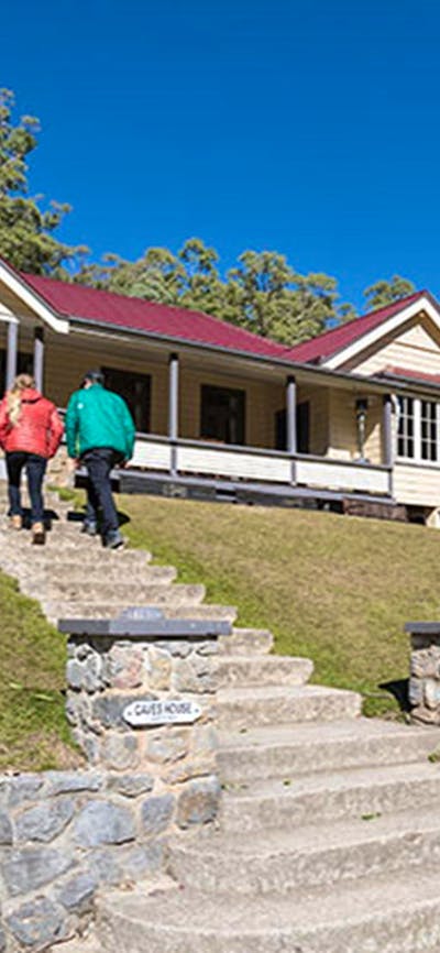 A couple at entry steps to Yarrangobilly Caves House East and West wings, Kosciuszko National Park.