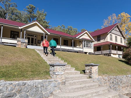 A couple at entry steps to Yarrangobilly Caves House East and West wings, Kosciuszko National Park.